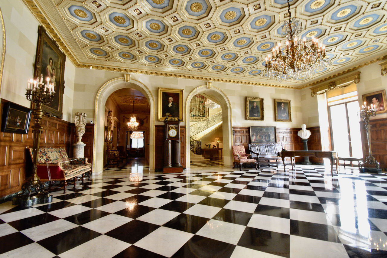 The entrance to the Nemours Estate has a black-and-white checkered floor and a beautiful blue and gold ceiling with lots of attention to detail. 